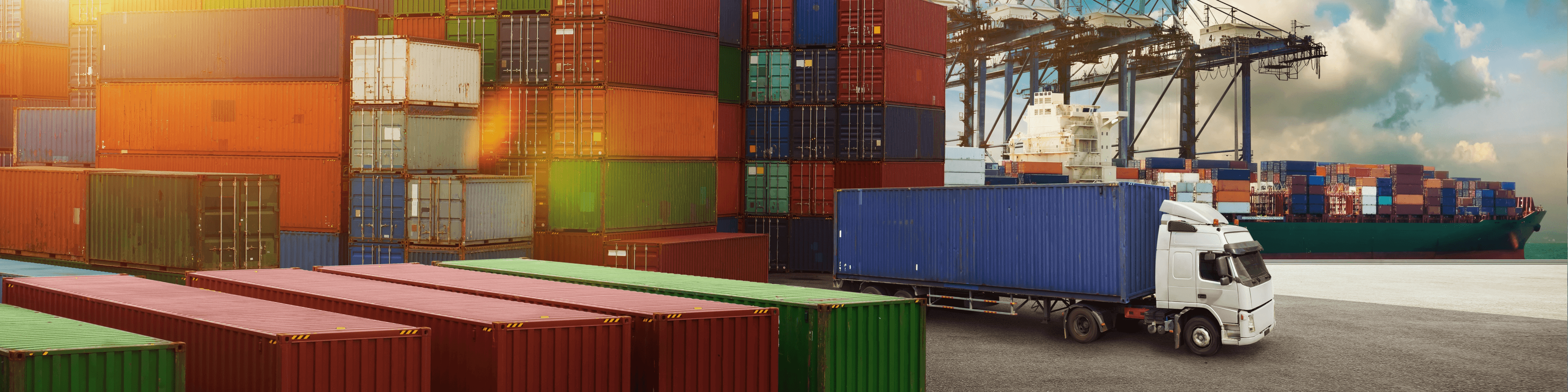 Containers in port for international LCL removals, truck ready for loading, ship in background.