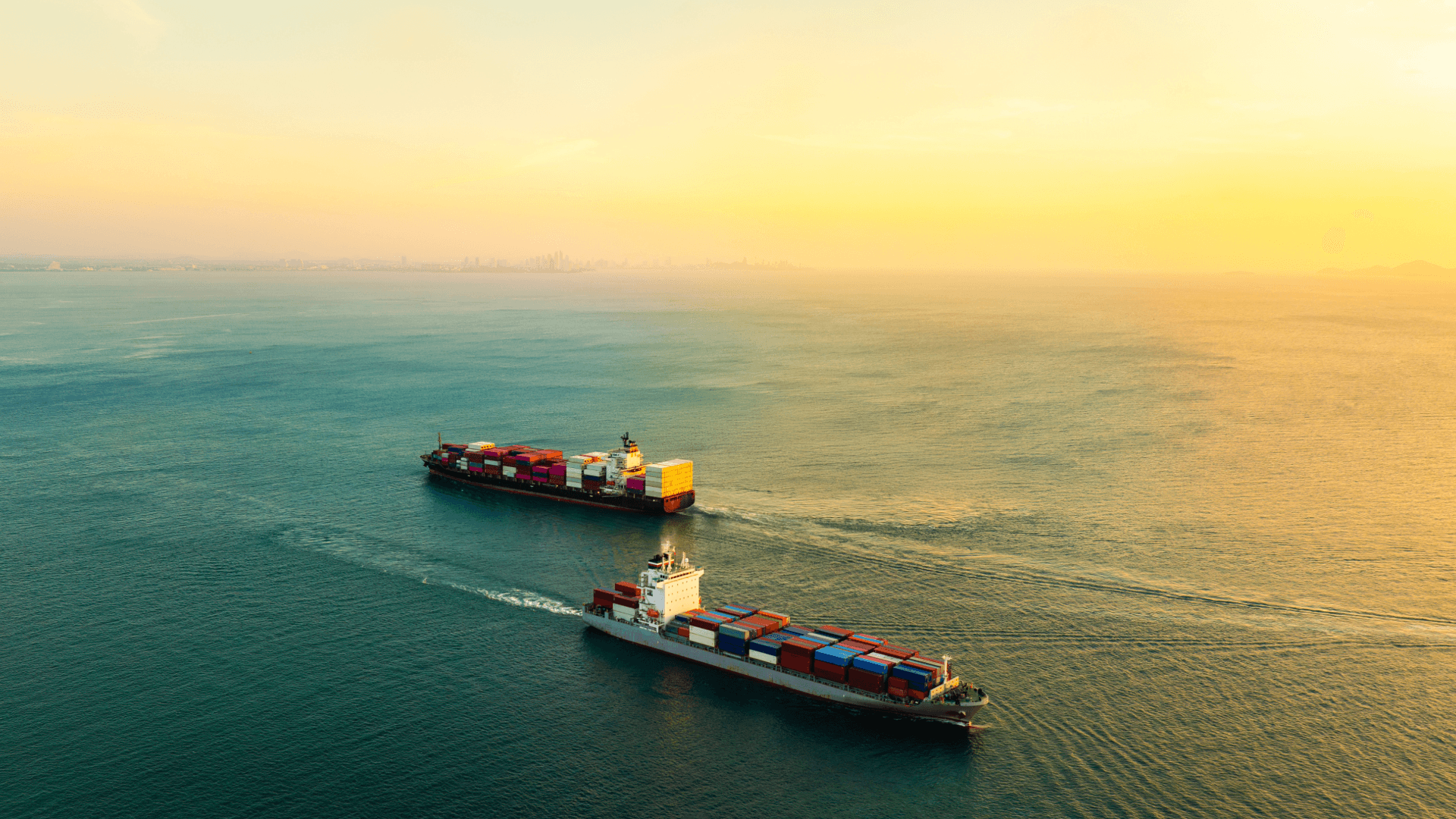 Loaded container ship of a shipping company at quay in large port with cranes at sunset.