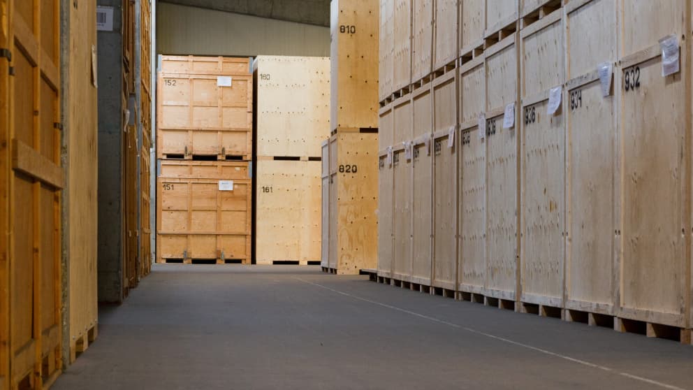 Row of numbered wooden crates in a secured moving storage facility for safe relocation storage