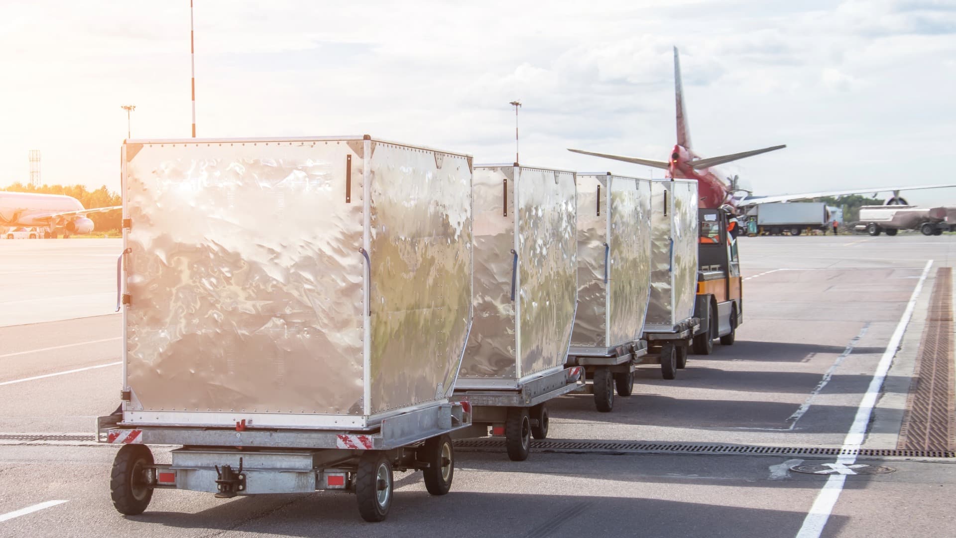 Luftfracht-Container auf Rollwagen am Flughafen-Vorfeld – Air Chargeable Weight als Basis für Frachtkosten