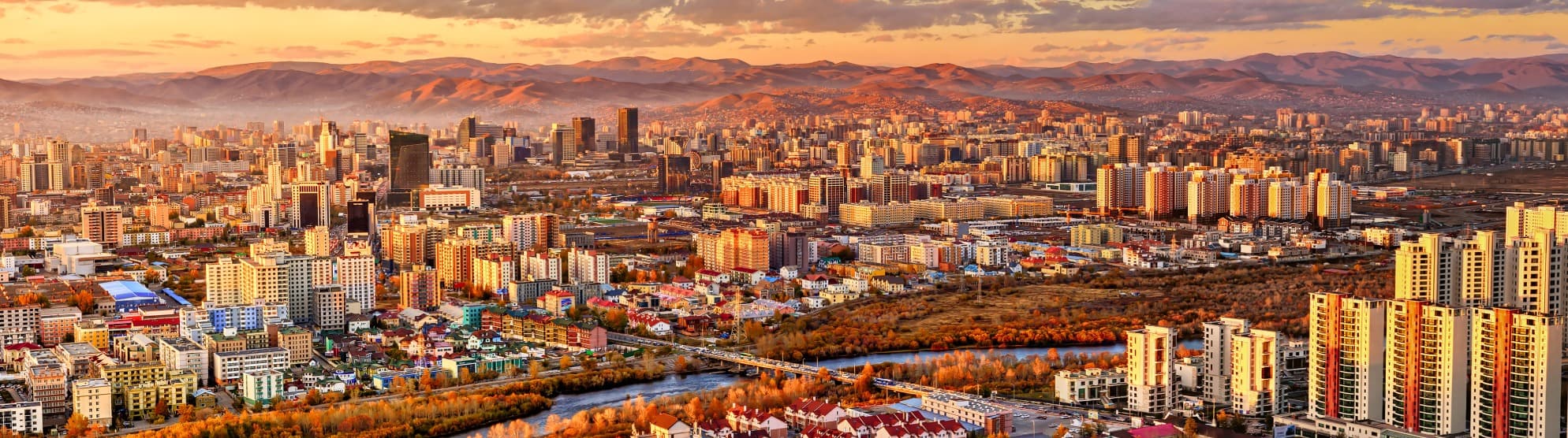 Panoramic view of Ulaanbaatar, Mongolia, with skyline, river and mountains at sunset
