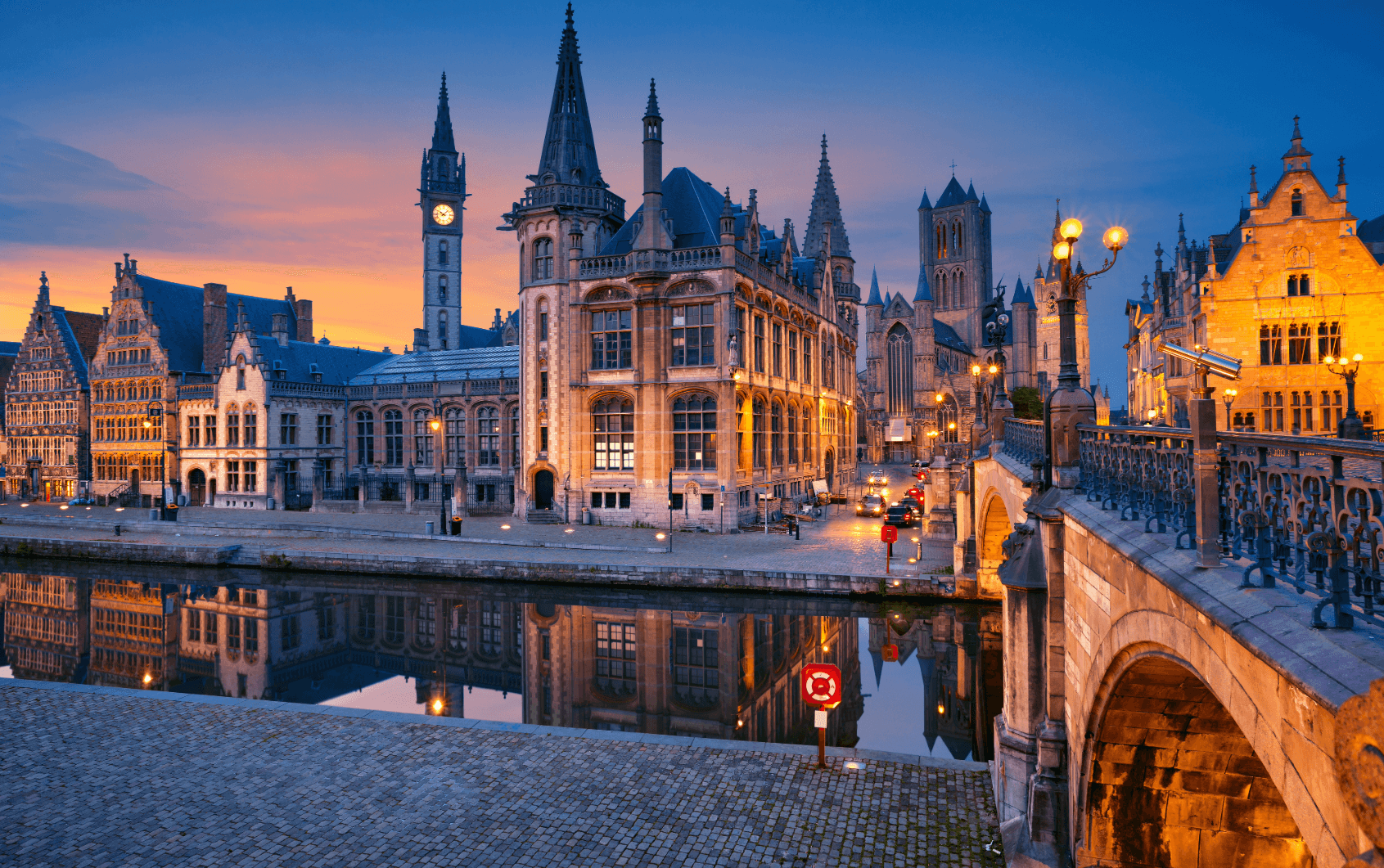 Historic old town of Ghent with canal and illuminated buildings in the evening