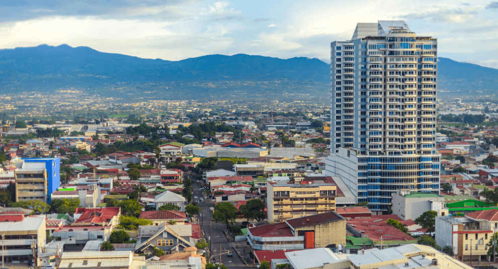City view in Costa Rica with a high-rise building, neighborhoods and mountains in the background