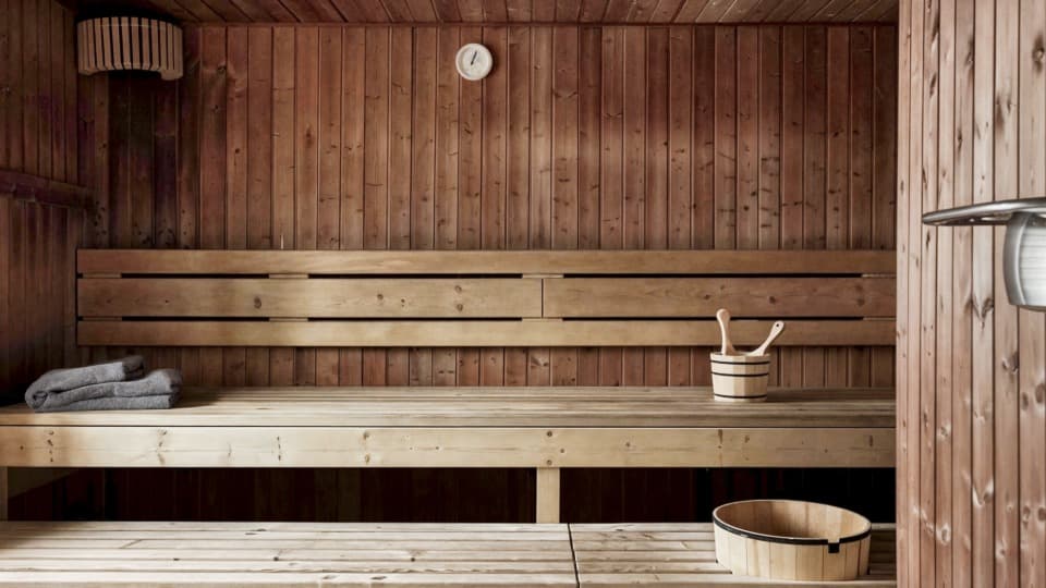 Wooden sauna in Finland with benches, bucket and towels