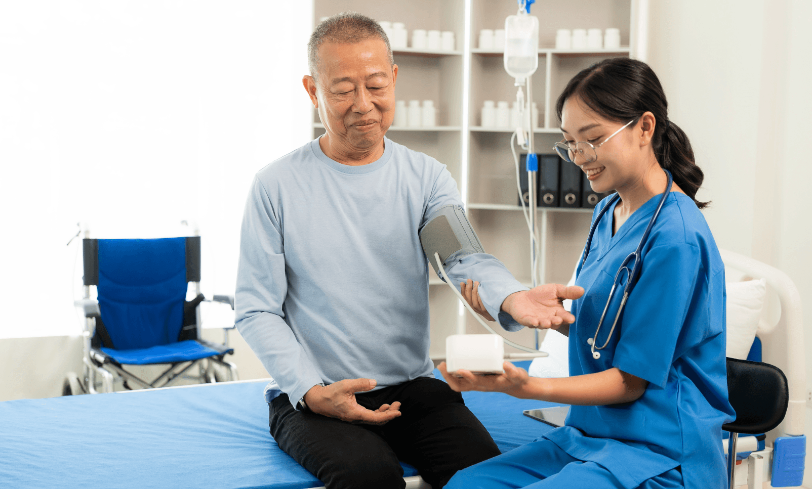 Älterer Patient bei Blutdruckmessung in einer Klinik in Südkorea mit Pflegekraft