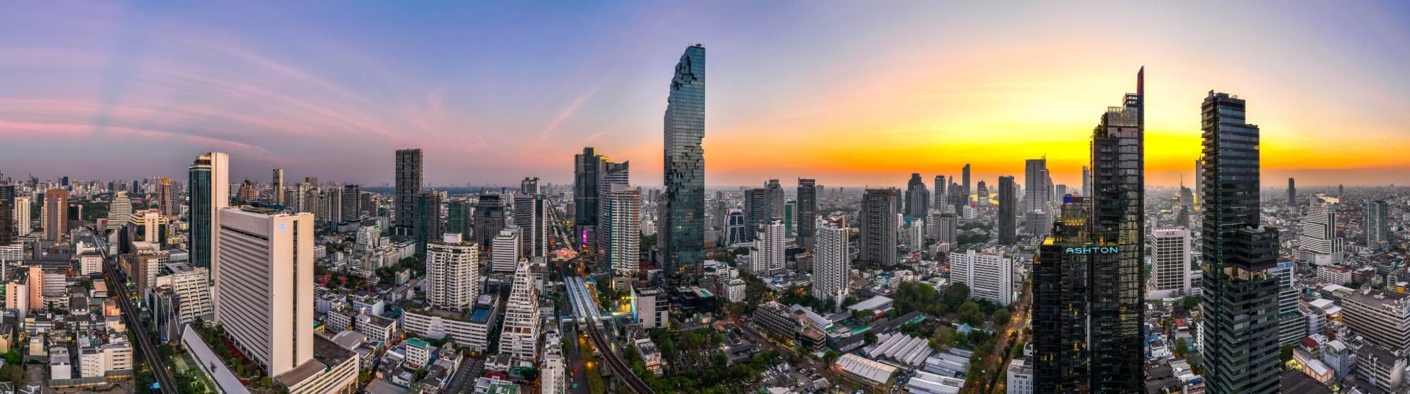 Farbenfrohes Stadtpanorama von Bangkok bei Sonnenuntergang als Zielregion für den sicheren Überseeumzug mit DACHSER & KOLB nach Thailand.