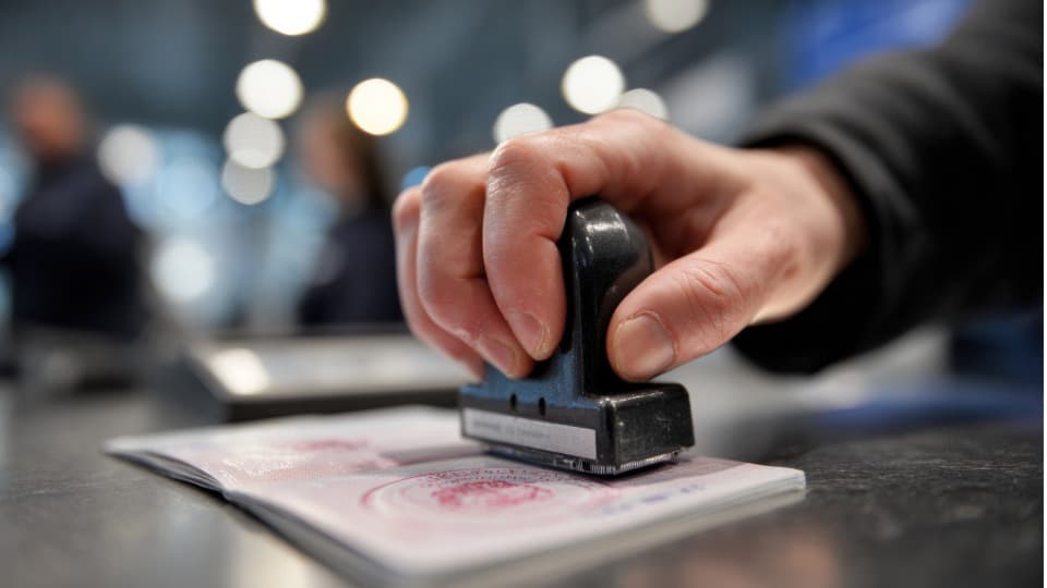 Grenzbeamter stempelt einen Reisepass bei der Einreise