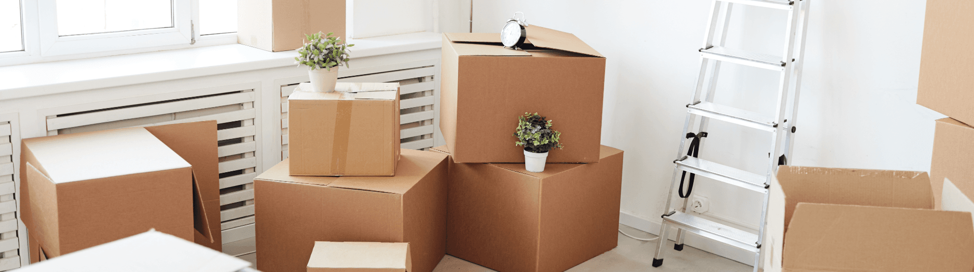 Several packed moving boxes of different sizes in a bright room, ready for the move.