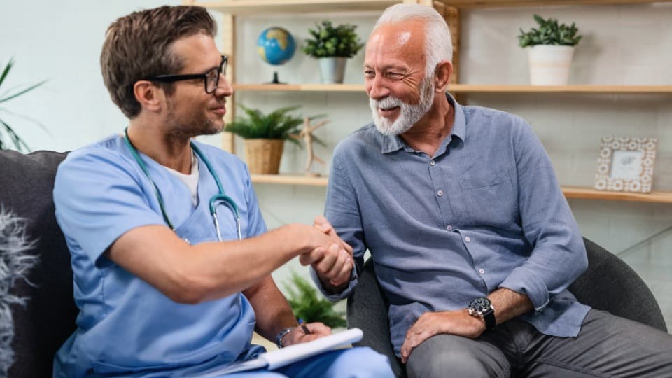 A primary care physician greeting a patient with a handshake – symbolizing personalized medical care in Italy.