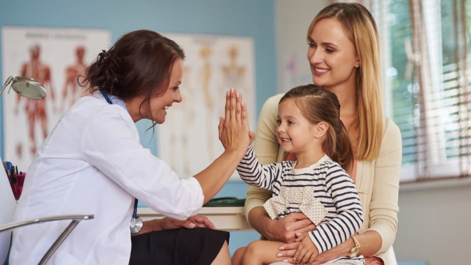 Doctor examining a child – information on mandatory health insurance and family coverage in Germany.