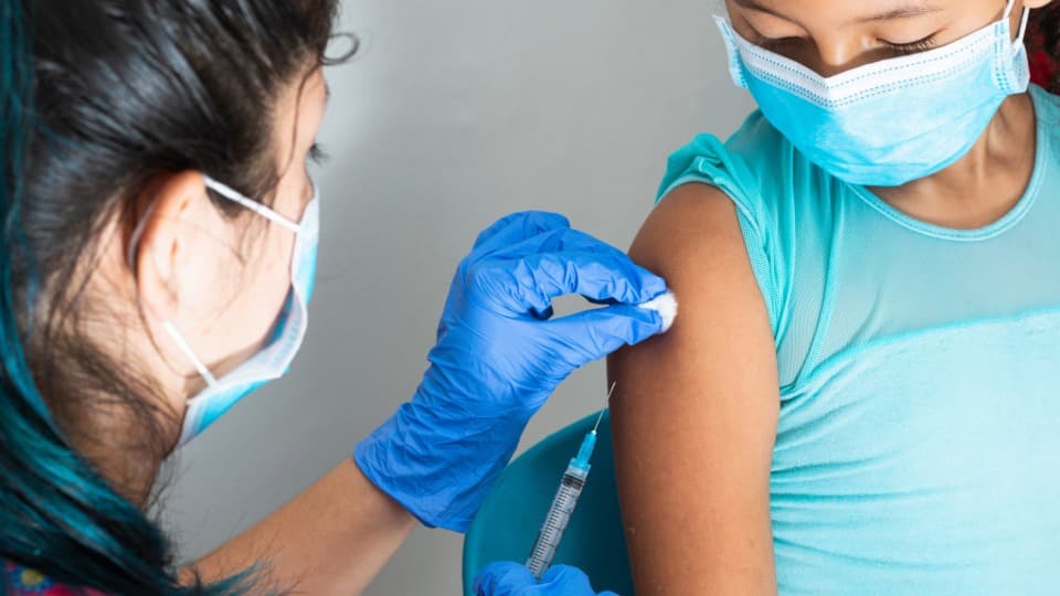 Eine kolumbianische Ärztin impft ein Kind - Gesundheitssystem in Kolumbien