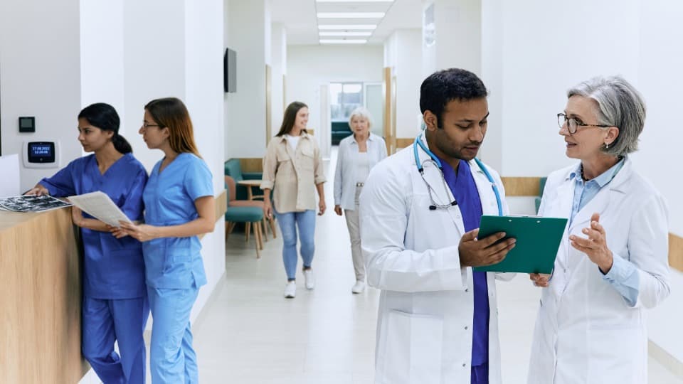 Hallway in a clinic in the United States, with several doctors and patients present.