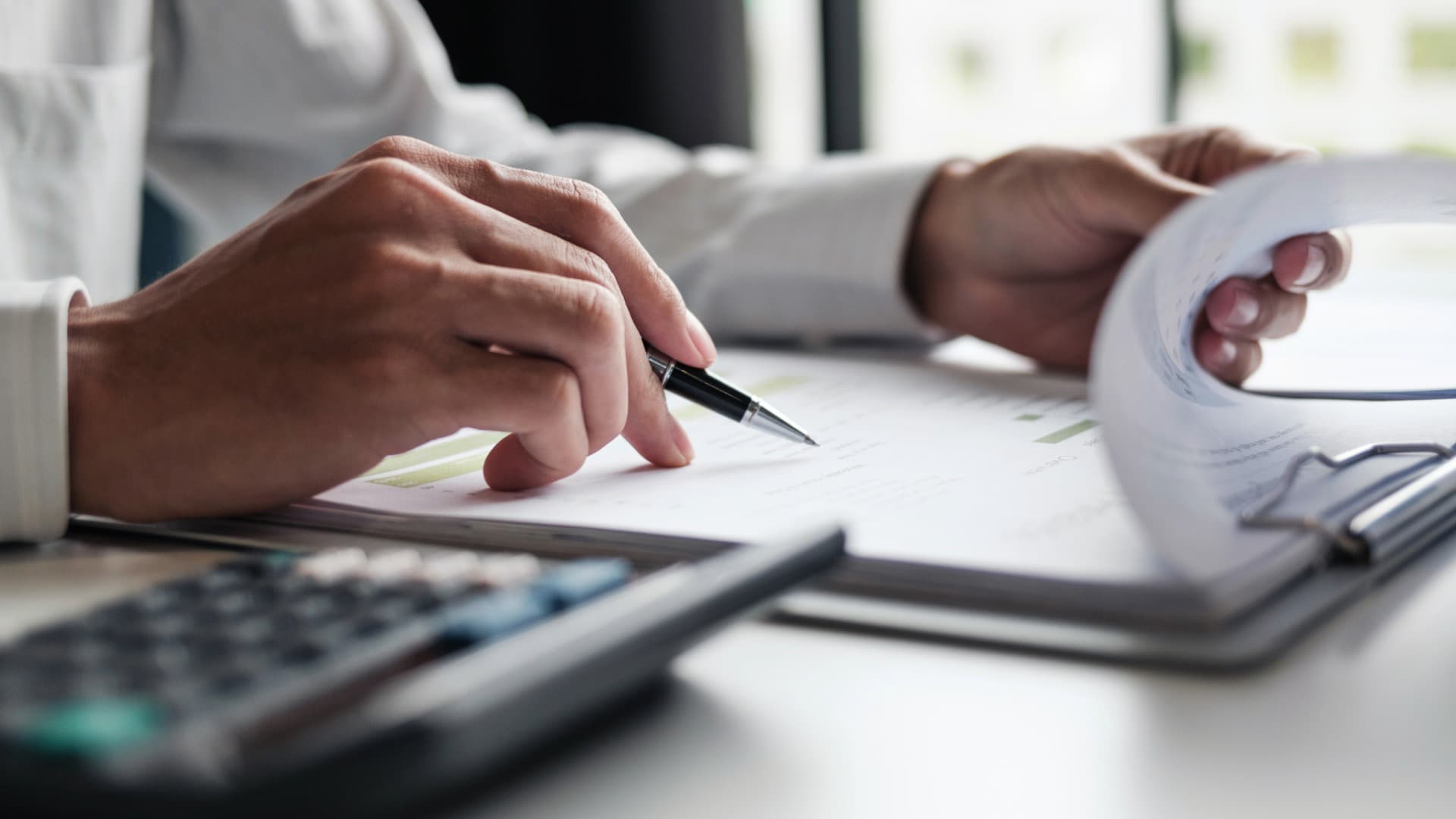 Hands review quote and cost calculation for edge protection (Kantenschutz) – documents, pen and calculator