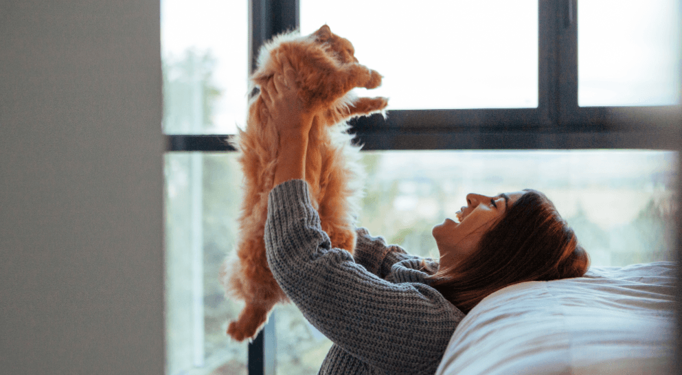 Woman lifts her cat after moving – strengthening emotional bond during a move with cats