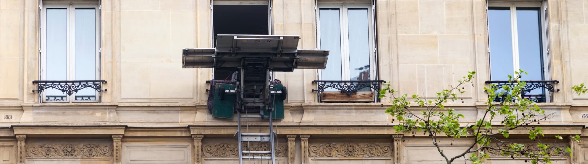 Furniture lift raises heavy cargo to an apartment window – safe transport of heavy items
