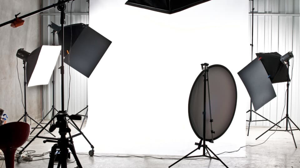 Ein Fotostudio mit aufgebauten Studioblitzen, Softboxen, Stativen und Reflektoren vor dem professionellen Umzug mit DACHSER & KOLB.