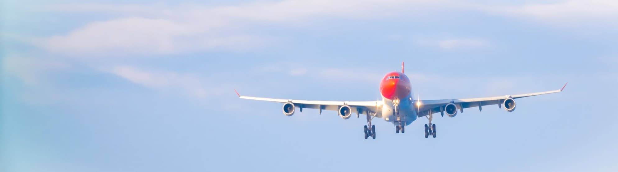 Flugzeug im Anflug vor blauem Himmel als Symbolbild für Thailand-Visum und Einreise