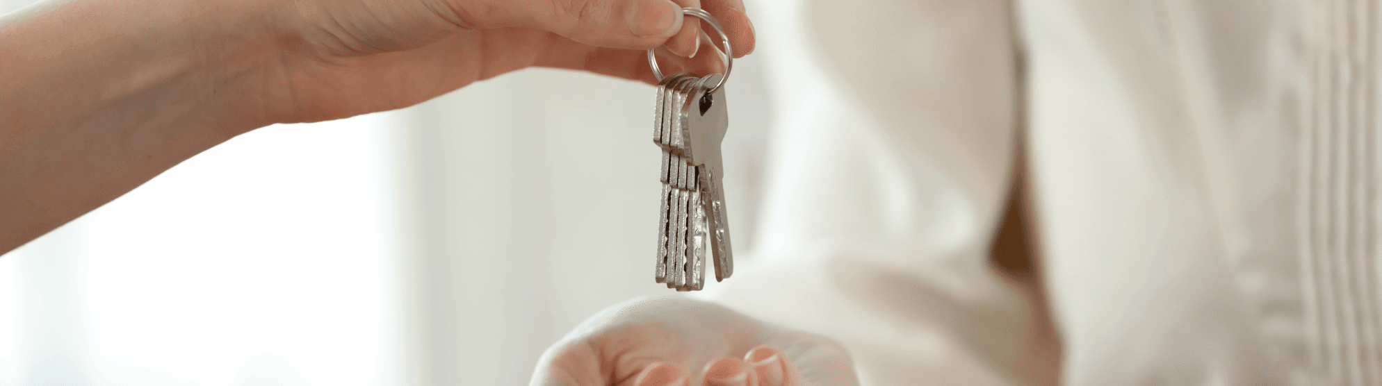 Handing over apartment keys – symbolizing move-in and tips for getting your first own flat