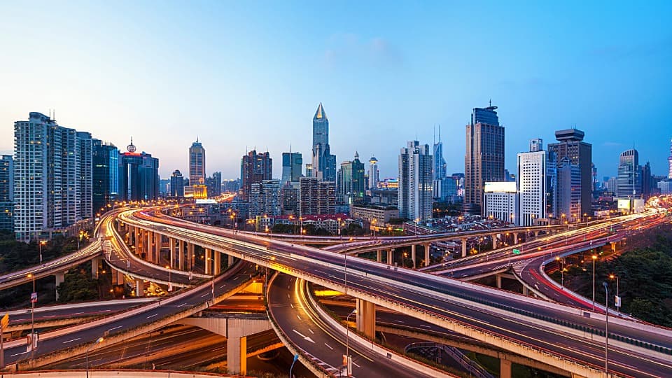 Das komplexe Autobahnkreuz der Nanpu-Brücke vor der Skyline von Shanghai für den perfekt koordinierten Umzug nach Asien mit DACHSER & KOLB.