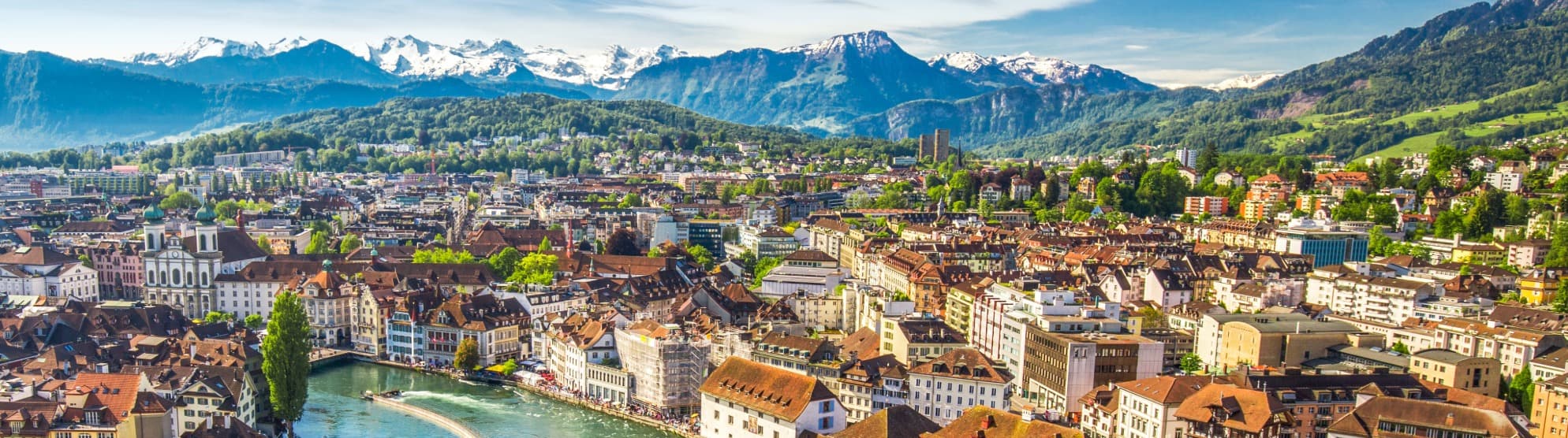 Panoramic view of the city of Lucerne with the Jesuit Church and the Swiss Alps in the background for an international move to Switzerland with DACHSER & KOLB.
