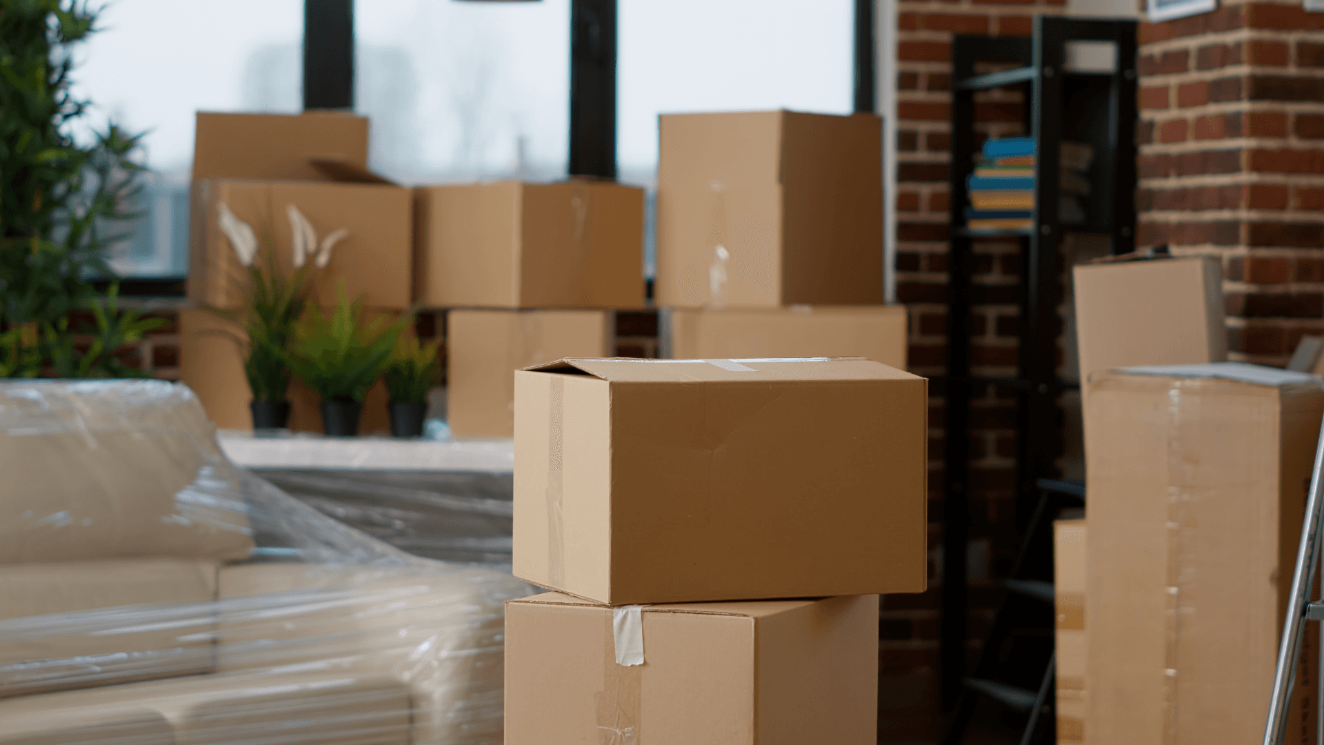 Several brown moving boxes of different sizes in a room with moving goods.