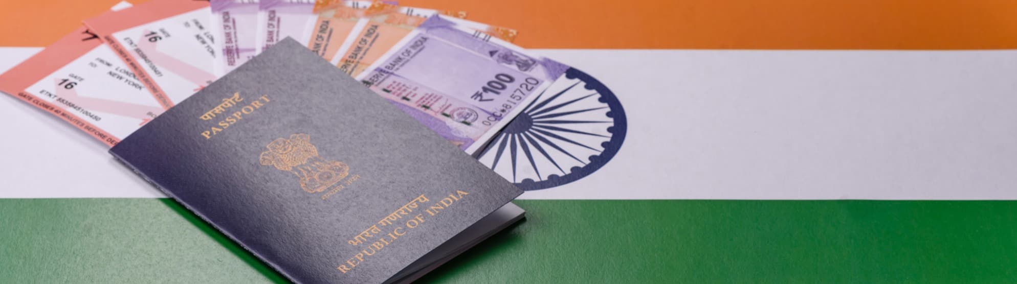Indischer Reisepass mit Visaunterlagen und Rupien auf der Flagge Indiens