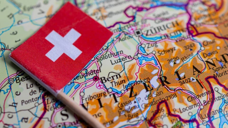 Schweizer Flagge auf Landkarte der Schweiz mit markierten Städten wie Zürich und Bern