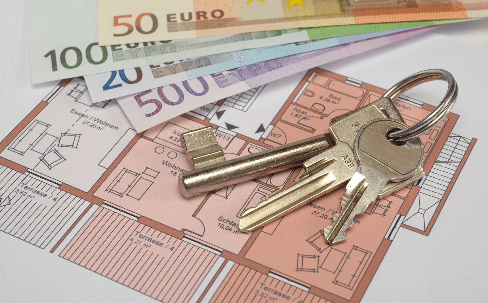 Schlüssel und Geldscheine auf Wohnungsplan – symbolische Darstellung der finanziellen Aspekte einer Wohnungsübergabe