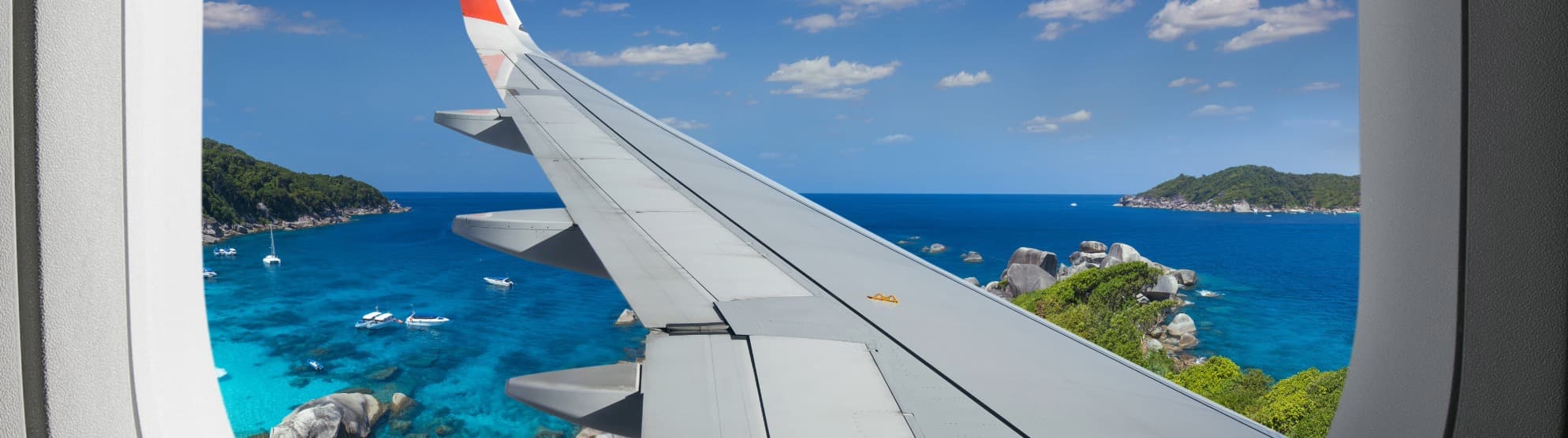 Blick aus dem Flugzeugfenster auf Thailands Küste – Symbolbild für Einreisebestimmungen und Zoll beim Thailand-Umzug.