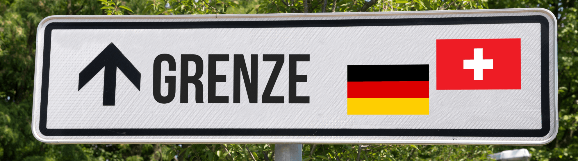 Schild „Grenze“ mit Pfeil sowie deutscher und Schweizer Flagge als Symbol für Zoll Schweiz