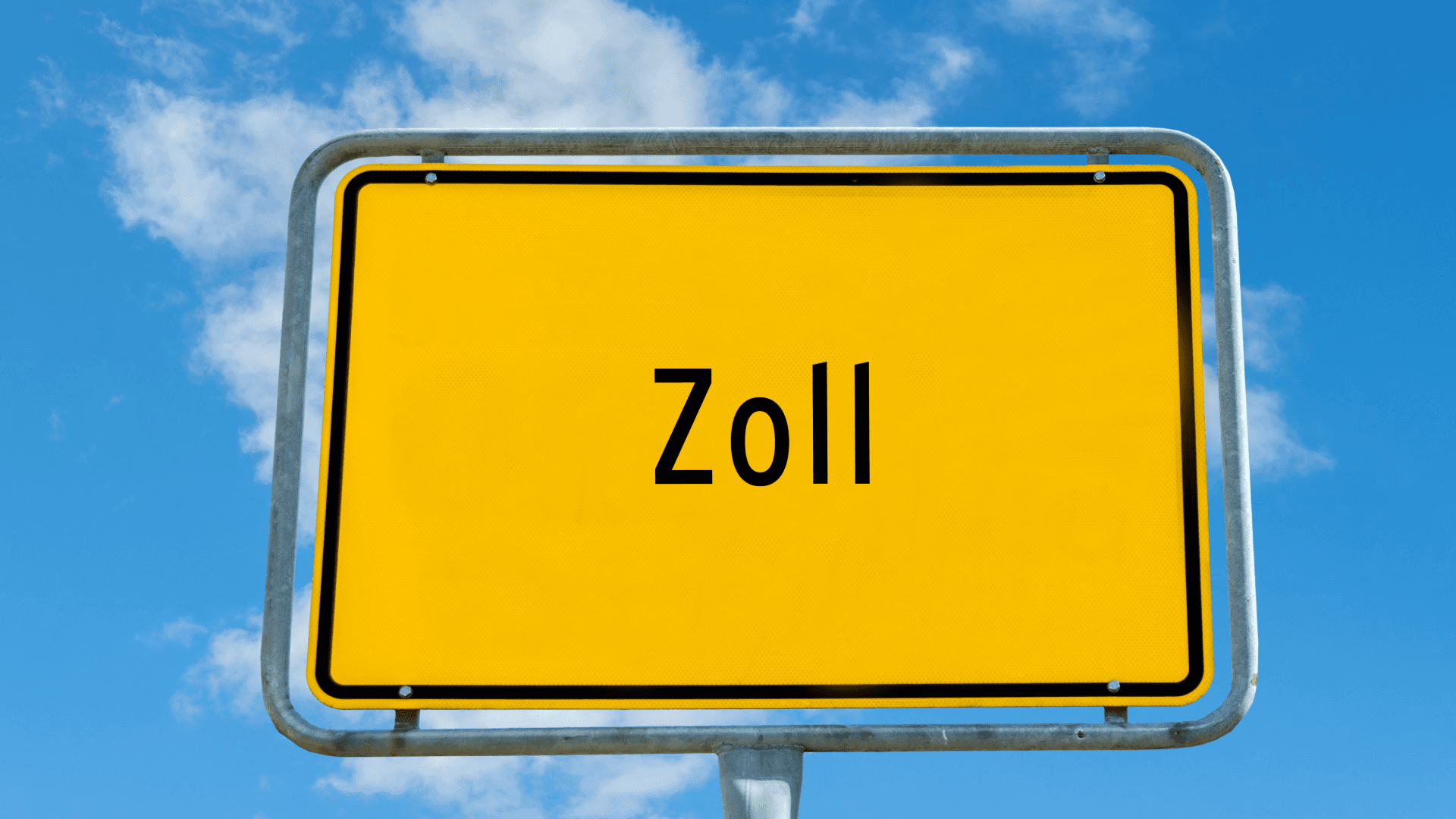 Gelbes Straßenschild mit Aufschrift „Zoll“ vor blauem Himmel als Symbol für Zollkontrolle an der Grenze