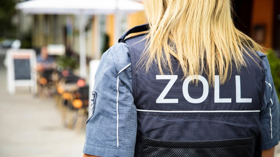 Rear view of a customs officer with “ZOLL” on the uniform, symbol for customs Thailand to Germany.