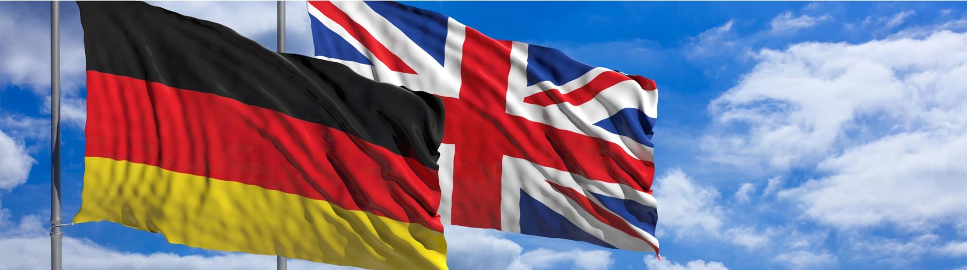Deutsche und britische Flagge wehen nebeneinander vor blauem Himmel als Symbol für Zoll UK nach Deutschland.