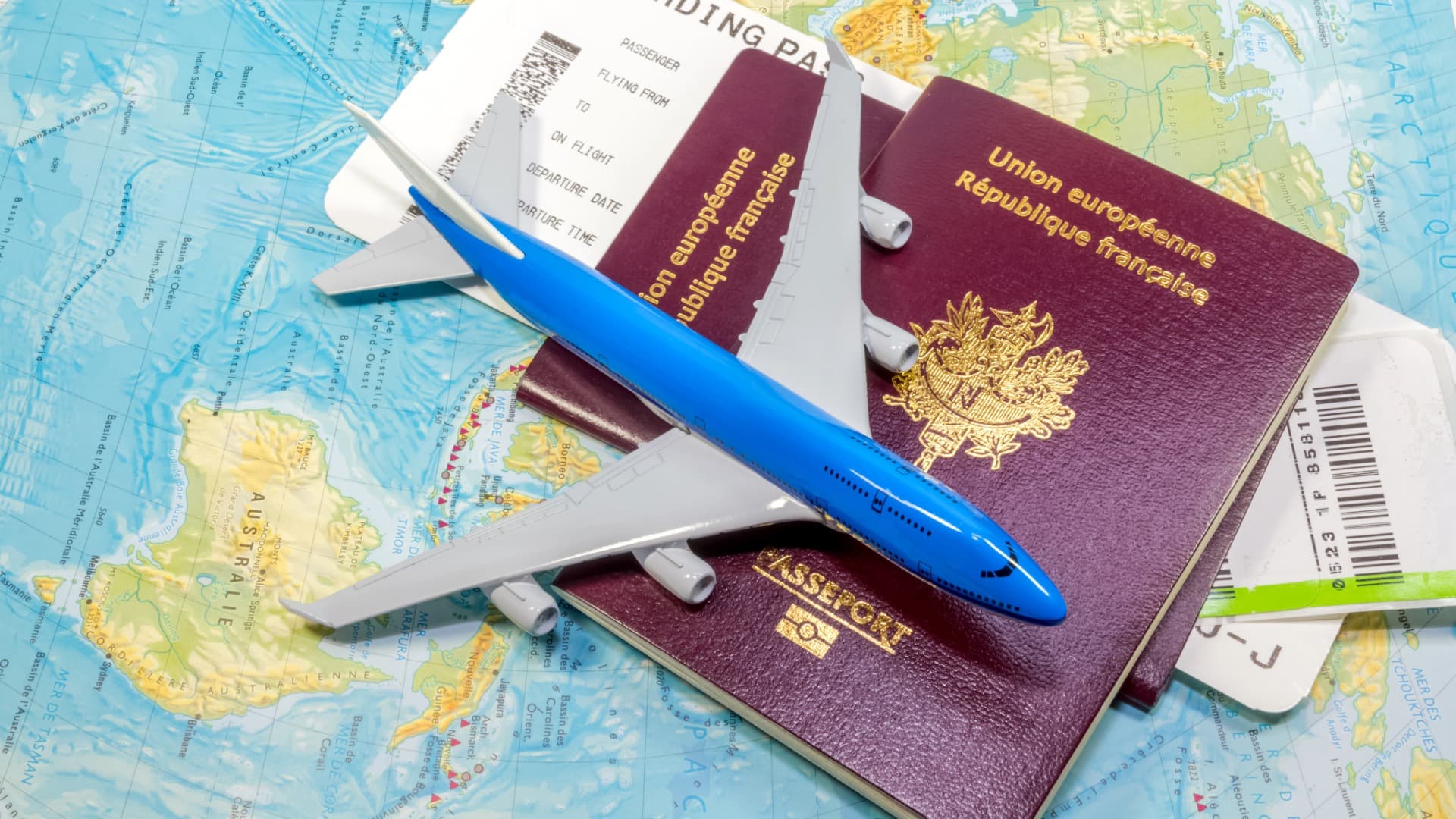 Reisepässe, Flugticket und Flugzeugmodell auf Weltkarte für Indien-Umzug