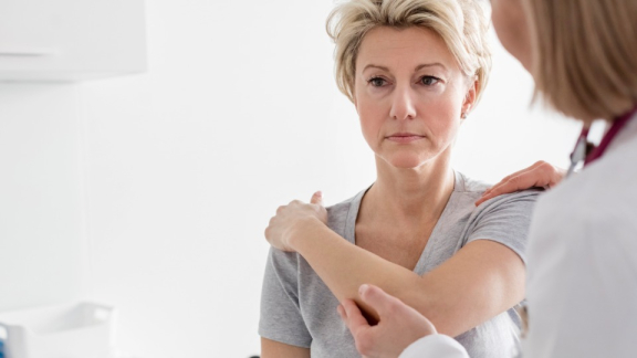 Eine polnische Ärztin untersucht den Arm einer Patientin