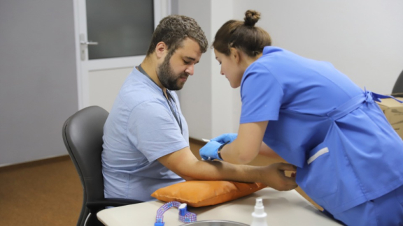 Eine österreichische Ärztin nimmt einem Patienten Blut ab