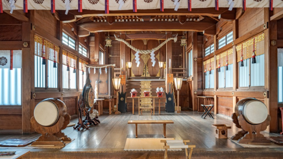 Innenraum eines traditionellen japanischen Schreins mit Trommeln und Holzaltar