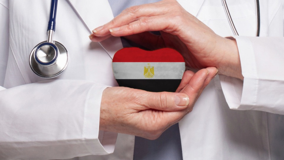 Egypt's healthcare system: A doctor holds a heart in the colors of the Egyptian flag protectively in his hands