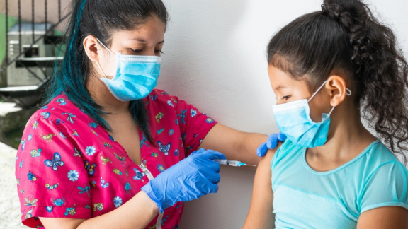 A Paraguayan girl receives an injection from a doctor