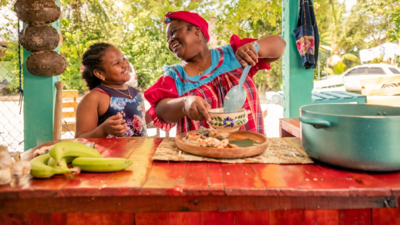 Culture in Colombia – A Colombian mother prepares a meal together with her daughter.