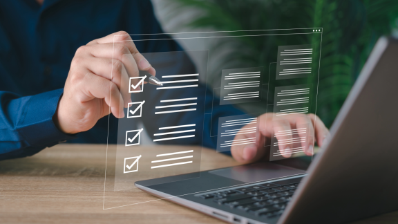 Hand am Laptop mit digitaler Checkliste als Symbol für die Planung der Auswanderung in die Mongolei