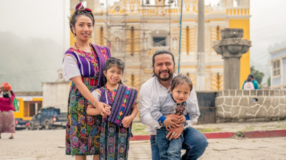 A happy family with two parents and two children stands in a city square in Ecuador – culture and the importance of family in Ecuador