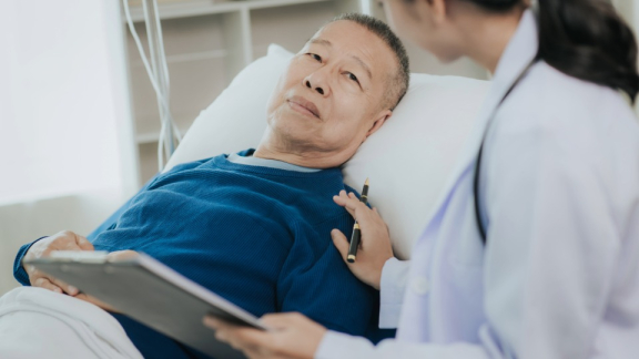 A Taiwanese doctor checks on the condition of a Taiwanese man in a hospital bed