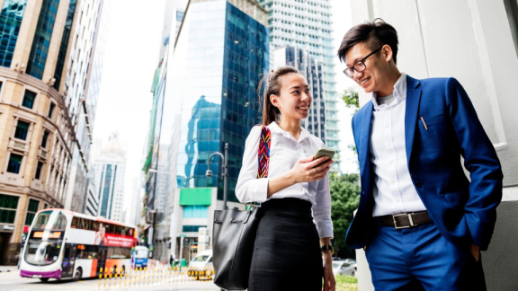 A woman and a man from Singapore are talking about their business on the street