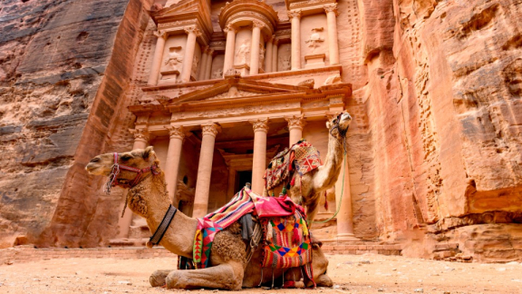 Two camels in front of the famous mausoleum at the UNESCO World Heritage Site of Petra, Jordan.