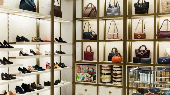 Ein luxuriöses Ankleidezimmer mit Handtaschen in beleuchteten Regalen vor dem Ausräumen und dem Möbeltransport durch DACHSER & KOLB.