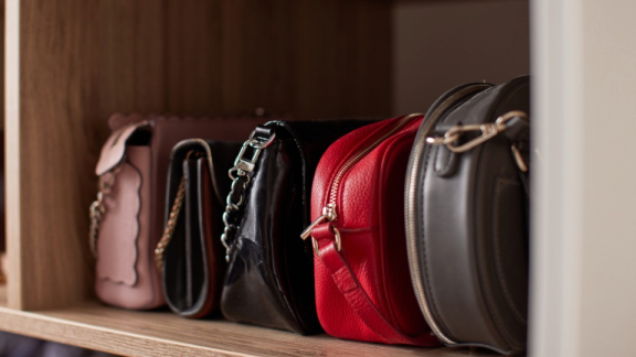 Eng aneinandergereihte Handtaschen im Regal, die vor dem Transport durch DACHSER & KOLB vor Reibung, Licht und Feuchtigkeit geschützt werden müssen.