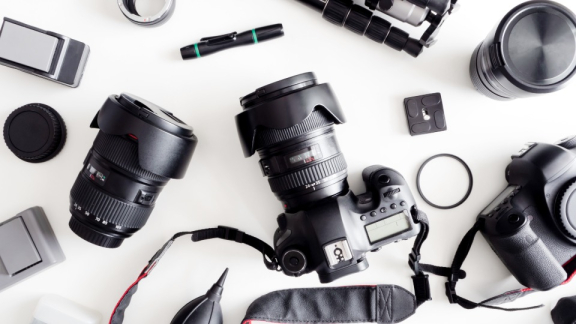 Eine strukturierte Übersicht von Fotoausrüstung mit Spiegelreflexkameras, Objektiven und Zubehör vor dem sicheren Verpacken für den Umzug mit DACHSER & KOLB.