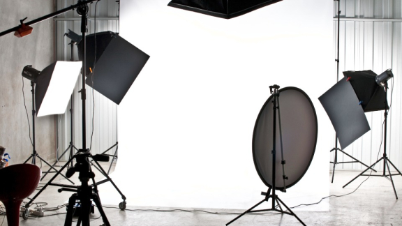 Ein Fotostudio mit aufgebauten Studioblitzen, Softboxen, Stativen und Reflektoren vor dem professionellen Umzug mit DACHSER & KOLB.