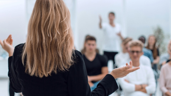 A presenter gives a talk to employees to prepare them for the office relocation.